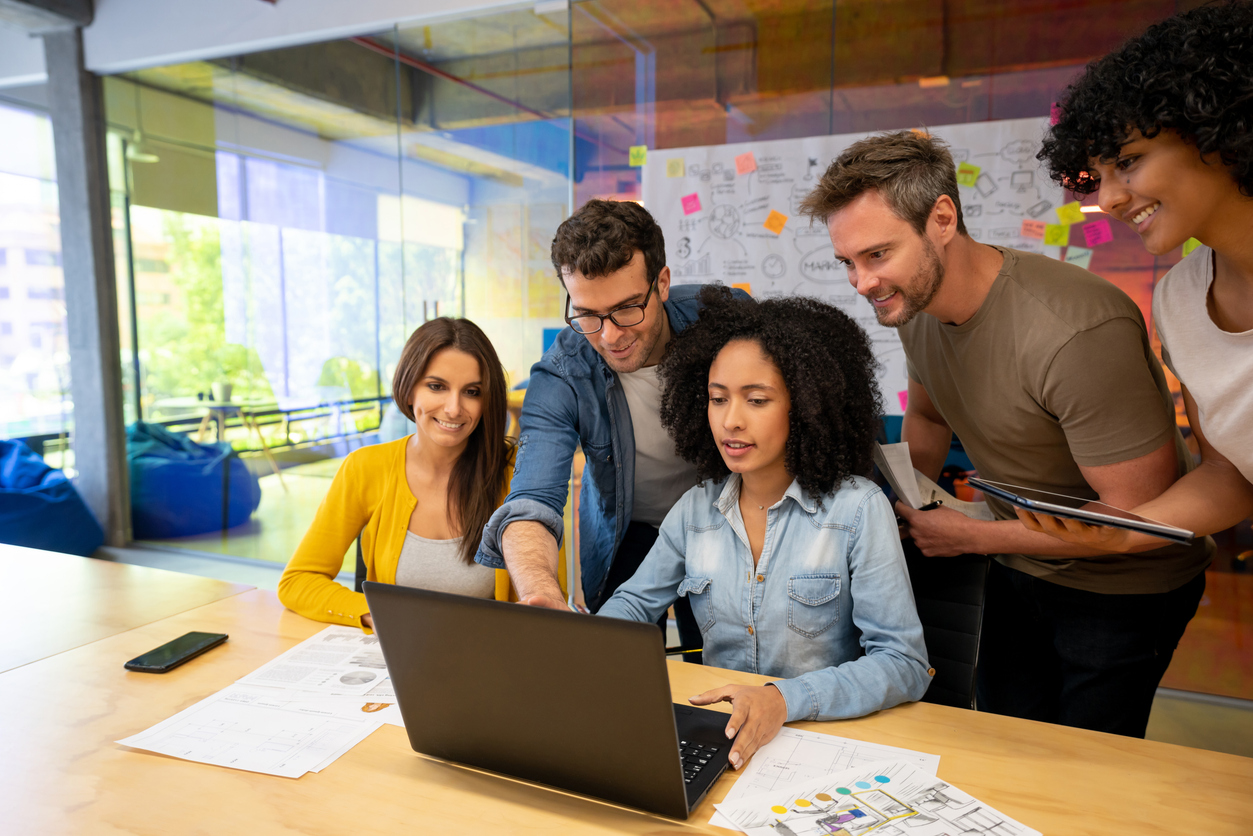 Group of people looking at laptop, working together